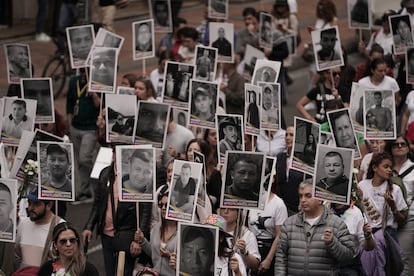 Manifestantes sostienen fotografías de firmantes de paz que han sido asesinados en Colombia.