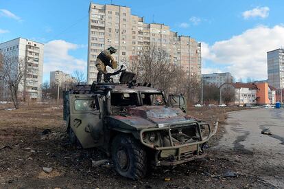 Militares ucranios examinan un vehículo blindado ruso destruido en la ciudad de Jarkóv, este domingo.