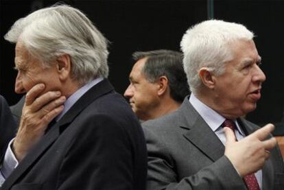 Jean-Claude Trichet, a la izquierda, de espaldas al ministro de Finanzas portugués, Fernando Teixeira dos Santos, ayer en Bruselas.
