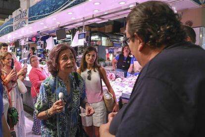 La reina Sofía conversa con un tendero del mercado del Olivar acompañado de la reina Letizia.