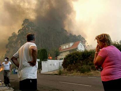 Los vecinos observan un incendio en la urbanización Aldea Nova, en el concello de Ames, A Coruña.