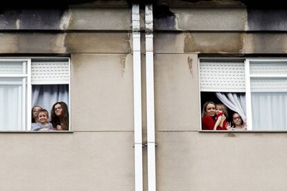 Miembros de la familia Dorrio Cuadrado saludan desde las ventanas de su piso en Ferrol. 