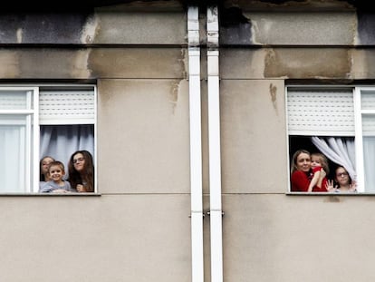 Miembros de la familia Dorrio Cuadrado saludan desde las ventanas de su piso en Ferrol. 