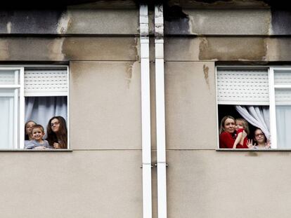 Miembros de la familia Dorrio Cuadrado saludan desde las ventanas de su piso en Ferrol. 