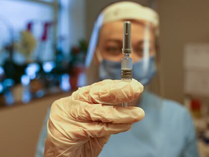 Pesquisadora exibe seringa com a vacina Coronavac