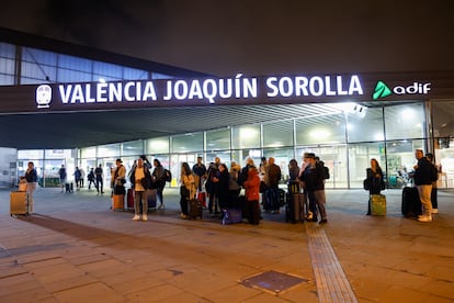 Un grupo de personas aguarda ante la estación Joaquín Sorolla cuando el temporal de lluvias ha obligado a suspender las conexiones de alta velocidad entre Valencia y Madrid.
