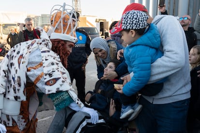 El Rey Melchor, atendiendo a un niño emocionado esta tarde en el puerto de Barcelona. 