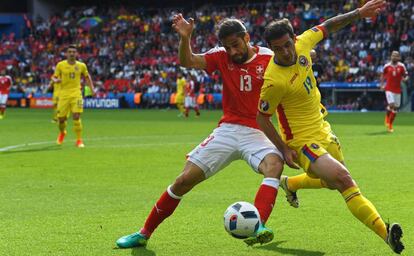 El lateral suizo Ricardo Rodriguez pugna con Bogdan Stancu.