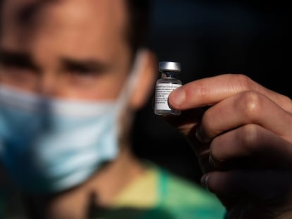 Un sanitario gallego sostiene una vacuna.