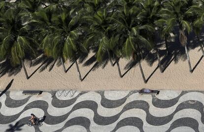 Un hombre duerme en un banco de la playa Leme en Río de Janeiro, Brasil.