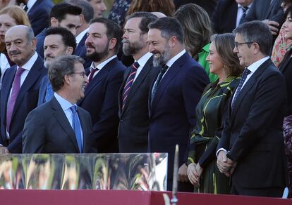 El presidente del PP, Alberto Núñez Feijóo, conversa con Santiago Abascal, líder de Vox, en la tribuna de las autoridades, el pasado 12 de octubre.