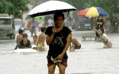 Un hombre camina en una calle de Manila, tras el monzón de 2002.