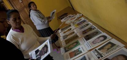 Varias mujeres colocan retratos de migrantes desaparecidos durante la novena caravana.