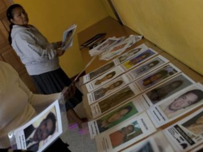 Várias mulheres colocam retratos de migrantes desaparecidos durante a nona caravana.