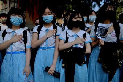 Los manifestantes, algunos con máscaras de gas, llevaron sus manos al pecho en señal de protesta y desplegaron una gran pancarta acusando a la policía de haber intentado asesinar a Tsang. En la imagen, estudiantes durante la concentración ante el colegio del estudiante herido, este martes.