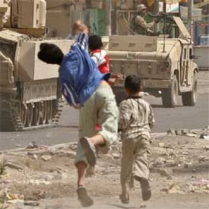 Jóvenes chiíes apedrean un convoy de tropas de EE UU en Bagdad.