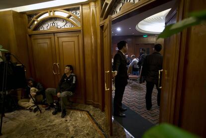 El grupo de cientos de familiares concentrado en el hotel pequinés denunció la escasez de información y los detalles confusos de la investigación que les van llegando, cuando llevan casi cinco días de angustia desde que el vuelo MH370 desapareciera con 239 personas a bordo, entre ellos 154 ciudadanos chinos. En la imagen, unos periodistas hacen guardia en el hotel donde se concentran los familiares, 12 de marzo de 2014.