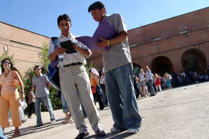 Colas de inmigrantes para recoger su documentación en las oficinas habilitadas en la antigua cárcel madrileña de Carabanchel.