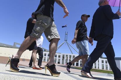 Funcionarios del Departamento de Asuntos Exteriores de Australia caminan en zapatos de mujer a las puertas del Parlamento durante la campaña 'Camina en sus zapatos', para concienciar sobre el problema de la violencia de género.