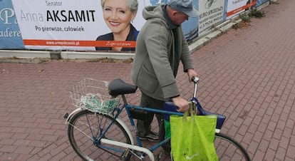 Un hombre pasa frente a un cartel electoral, el 14 de octubre, en Varsovia.