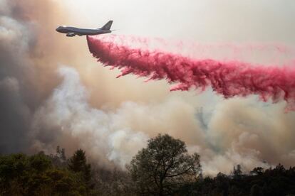 Un avión lucha contra el fuego con un producto retardante sobre el incendio de Deer Park, California, en EE UU.