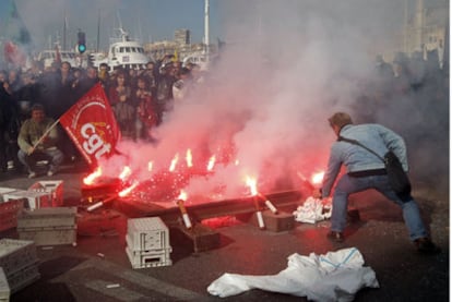 Trabajadores en huelga queman bengalas en una manifestación en el puerto de Marsella.