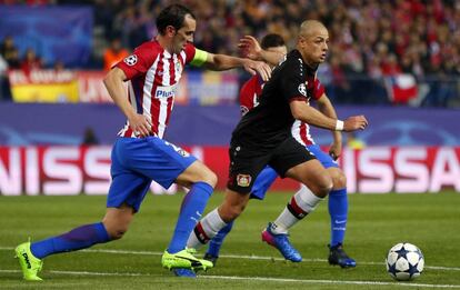 Chicharito controla el balón ante la marca de Diego Godín