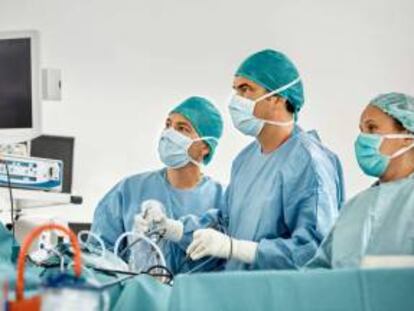 Cirujanos observan un monitor durante una intervención de rodilla. Getty