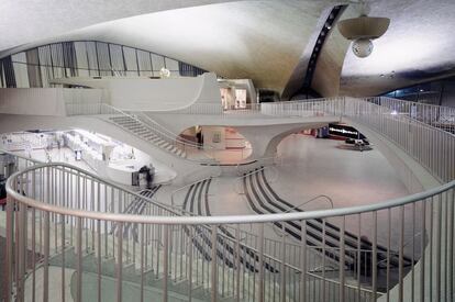 Terminal de la TWA en el aeropuerto John F. Kennedy de Nueva York, obra maestra de Eero Saarinen, terminada en 1962, un año después de la muerte del arquitecto, caracterizada por un fascinante neoexpresionismo que enlaza con la escultura y se asemeja en su exterior a un pájaro con las alas abiertas y, en su interior, a una gruta de dulces formas.