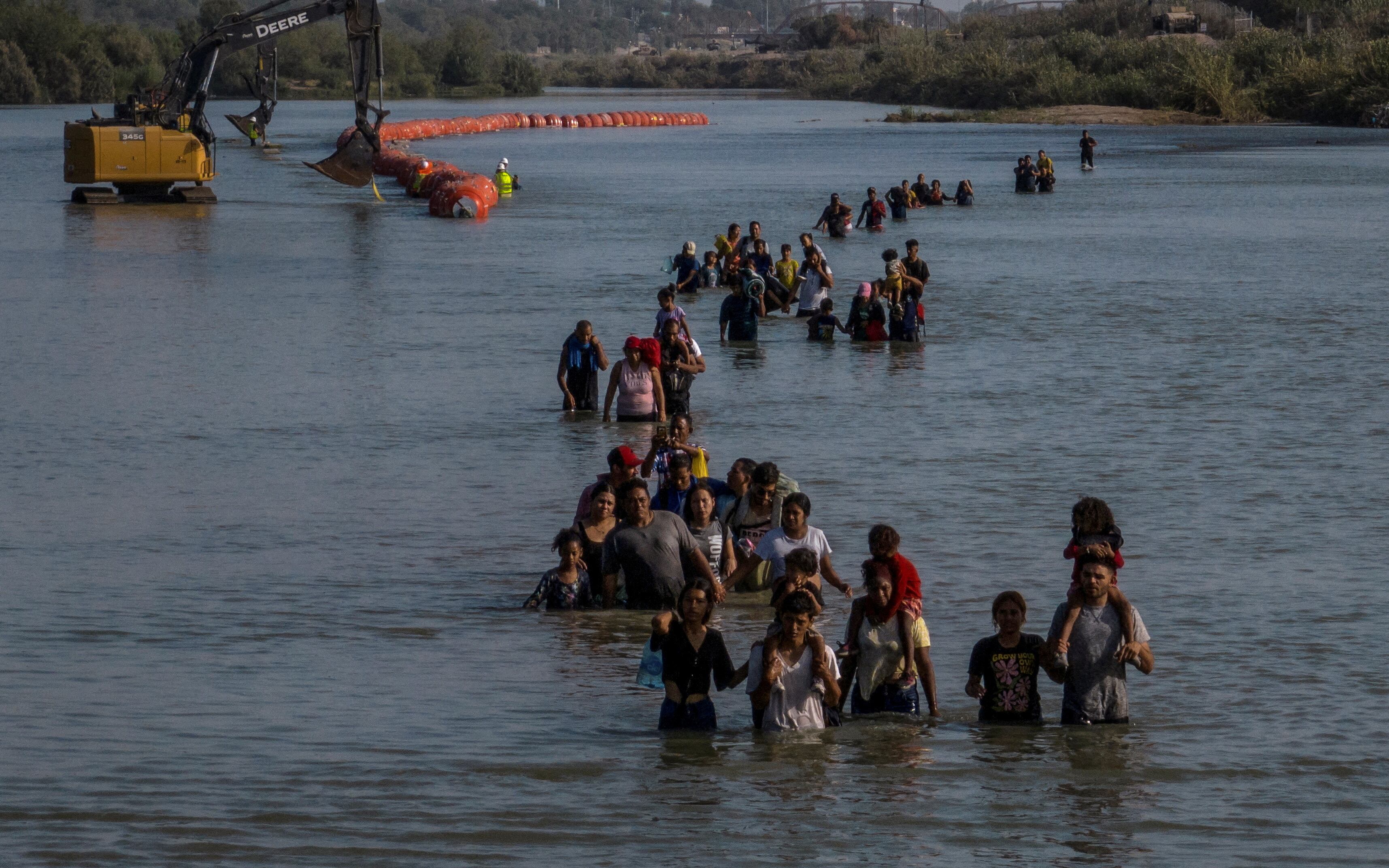 Un grupo de migrantes cruza el río Bravo cerca de la zona de Eagle Pass (Texas).