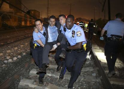 Miembros de los equipos de rescate trasladan a uno de los pasajeros del tren accidentado.
