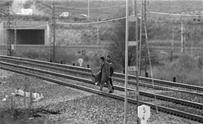 Dos toxicómanos cruzan la vía, en Pitis, para ir a comprar droga al pobaldo de La Quinta, en una imagen de archivo.