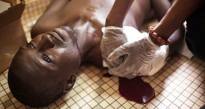 Un manifestante contra el golpe de Estado es tratado en Ouagadougou antes de su muerte por herida de bala.