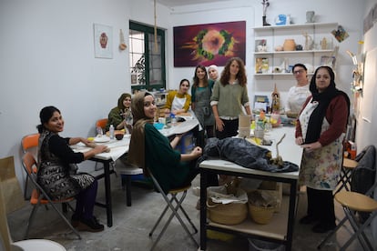 La artista y profesora Carina Moreira, en el centro con un delantal vaquero, en el taller de cerámica que imparte a mujeres refugiadas y solicitantes de asilo en Carabanchel (Madrid).