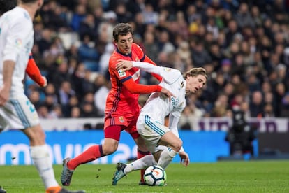 El centrocampista croata del Real Madrid, Luka Modric (d), protege el balón ante el acoso del jugador de la Real Sociedad, Mikel Oyarzabal.