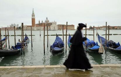 Uma pessoa passeia vestida com trajes de época pelas ruas de Veneza.