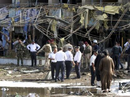 Polic&iacute;a y bomberos iraqu&iacute;es en la escena de un atentado en Bagdad.