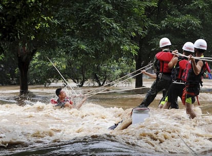 Los equipos de rescaten sacan a un hombre atrapado en una fuerte corriente tras las lluvias caídas en el río Lijiang, en Guilin (China).