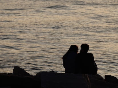 A couple sit on a seashore in Tel Aviv, Israel on December 30, 2022. (Photo by Jakub Porzycki/NurPhoto via Getty Images)