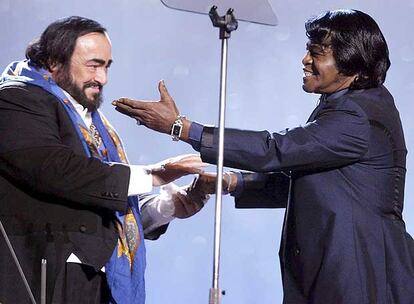 James Brown, junto al tenor italiano Luciano Pavarotti, en el escenario durante el concierto <i>Pavarotti y Amigos</i> en el Novi Sad de Modena, Italia. Brown se ganó el título de <i>el trabajador más duro del mundo del espectáculo</i>, por la intensidad de sus actuaciones y el número de conciertos.