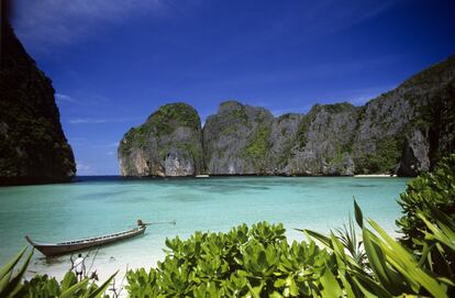 <p><strong>¿Dónde está?</strong> Es Maya Beach, en las islas Phi phi de Tailandia. <strong>¿Por qué es famosa?</strong> Por haber sido el escenario natural de 'La playa', película protagonizada por Leonardo DiCaprio en plena resaca de su fama mundial gracias a 'Titanic' (1997). Si en aquella terminaba ahogándose, aquí nunca se aleja demasiado de la orilla. <strong>¿Cuál es su problema?</strong> Durante el rodaje muchos ambientalistas acusaron al equipo de la película de alterar el aspecto de la bahía para adecuarlo a las necesidades de la ficción, pero lo peor llegó después: miles de turistas se acercaban cada día para ver los escenarios naturales de la película de DiCaprio. Si bien muchas zonas marinas de Tailandia permanecen cerradas desde mayo a octubre para su conservación, la demanda turística de Maya Bay hacía que nadie quisiese cerrarla. Pero este año se ha llegado a un punto de no retorno y las autoridades la mantienen cerrada. "Es como si alguien hubiese trabajado durante décadas sin descansar", afirmó el científico marino Thon Thamrongnawasawat <a href="https://www.theguardian.com/film/2018/mar/28/thailand-beach-leonardo-dicaprio-closing" target="_blank">al diario británico The Guardian</a>. Este cierre temporal ayudará a la rehabilitación de la flora y la fauna y, una vez reabierto, las autoridades establecerán límites: solo 2.000 turistas al día y nada de barcos anclando dentro de la bahía.</p>