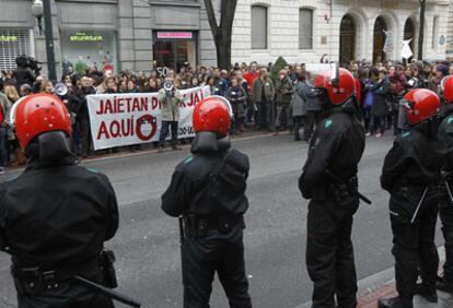 Efectivos de la Ertzaintza a la entrada de un comercio de la Gran Vía de Bilbao ante las protestas de los sindicatos.