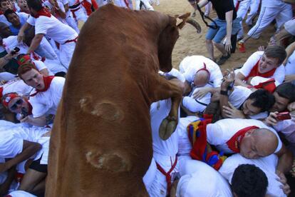 Montonera en la plaza.Varios mozos en apuros frente a un toro, en el primer encierro de San Fermín.