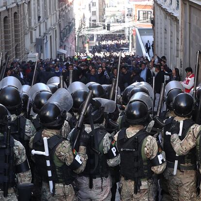 AME6897. LA PAZ (BOLIVIA), 26/06/2024.- Integrantes de la Policía Militar se forman frente a simpatizantes del presidente Luis Arce durante una protesta contra los militares que tomaron la sede del Gobierno de Bolivia, este miércoles en La Paz (Bolivia). Este miércoles un grupo de militares encabezados por el que hasta hoy era el Comandante General del Ejército de Bolivia, Juan José Zuñiga, tomó la plaza y con un tanque tiró la puerta de la sede del Gobierno del presidente Luis Arce quien calificó la acción como un "intento de golpe de Estado". EFE/ Luis Gandarillas