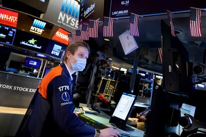 In this photo provided by the New York Stock Exchange, trader Colby Nelson works on the trading floor, Monday, Feb. 7, 2022. Several big companies are on deck this week to report their results, including Pfizer on Tuesday and Walt Disney on Wednesday. Twitter and Coca-Cola will report on Thursday. (Allie Joseph/New York Stock Exchange via AP)