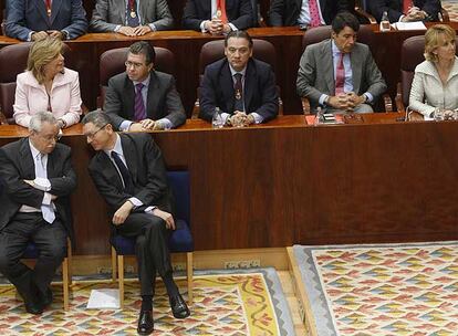 Joaquín Leguina y Alberto Ruiz-Gallardón (en primera fila) siguen el pleno extraordinario ante las filas del Gobierno regional.