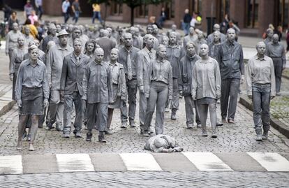 Manifestantes vestidos con ropa gris y con el pelo y la cara del mismo color participan en una protesta con motivo de la Cumbre de jefes de Estado y de Gobierno del G20 en Hamburgo, (Alemania).