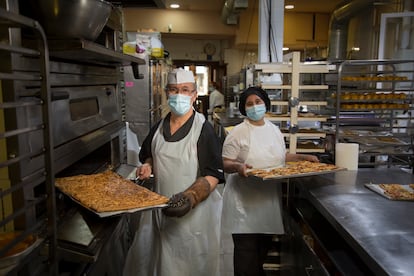 El panadero Miguel Ángel Navarro y su compañera Rajaa  Harrouda, en la panadería Horno la santiaguesa en la Calle Mayor de Madrid.