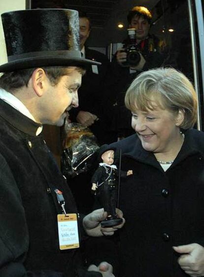 Un hombre vestido de deshollinador saluda a Angela Merkel ayer en Merzig (Estado de Sarre).