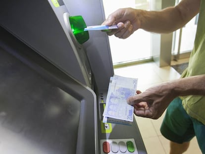 Un usuario retira efectivo de un cajero automático.